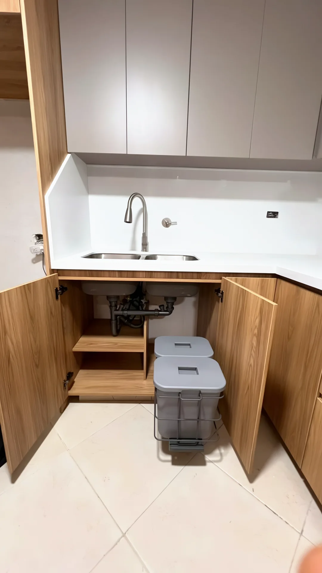 Mueble bajo el lavaplatos abierto: entrepaño en madera y canecas de reciclaje extraíbles